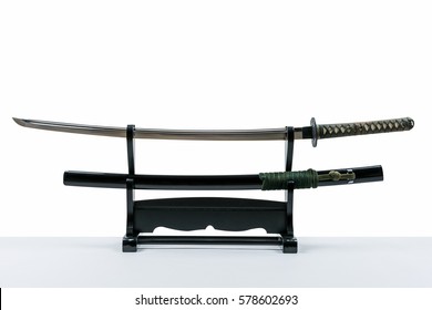 Japanese iaido sword in black wooden stand and white background. Still life studio shot of Japanese sword.