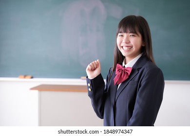 A Japanese junior high school girl strikes a fist pump in the classroom