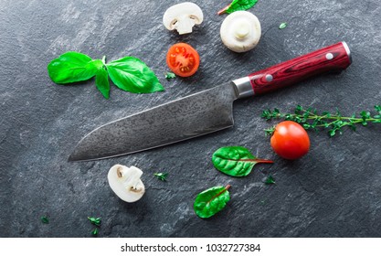 Japanese Knife Made Of Damascus Steel Lies On A Table Near The Vegetables. View From Above