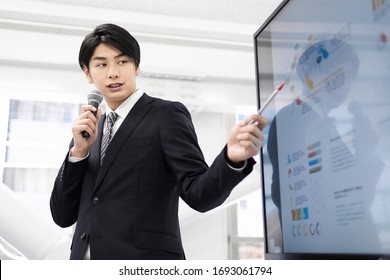 A Japanese Male Businessman Giving A Presentation.