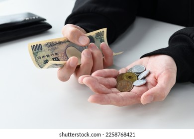 Japanese man' hands suffering from lack of money - Shutterstock ID 2258768421