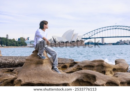A Japanese man relaxing in front of the Sydney Opera House