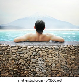 Japanese Man Soaking In Outdoor Onsen Hot Spring With Mt. Fuji View In Winter.