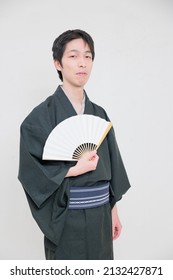Japanese man wearing a kimono with an open Japanese fan