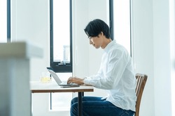 Japanese Man Working On A Computer At Home
