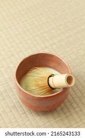 Japanese matcha tea in a bowl and tea whisk on tatami