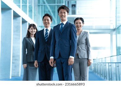 Japanese men and women in suits standing in the company lobby