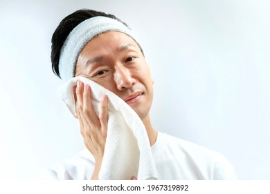 Japanese middle-aged man wiping his face with a towel