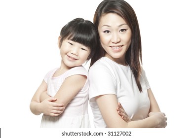 Japanese Mother With Daughter Family Portrait Shot Against White Studio Background