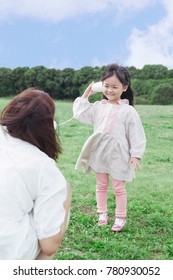 Japanese Mother And Daughter Playing With Paper Cup Phone