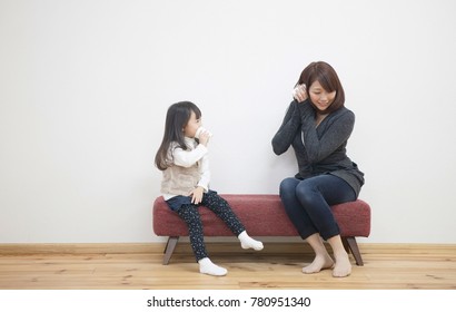 Japanese Mother And Daughter Playing With Paper Cup Phone