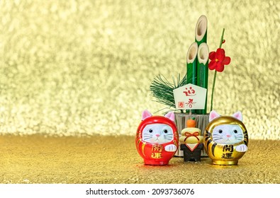 Japanese New Year's Greeting Card Of A Bamboo Kadomatsu Written Congratulations, Welcoming Spring, A Kagami Mochi Rice Cake And Two Cat Daruma Figurines Written Good Luck On A Golden Background.