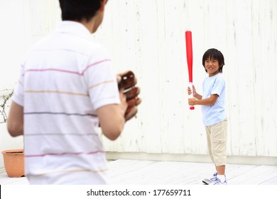 Japanese Parent And Child Playing Baseball