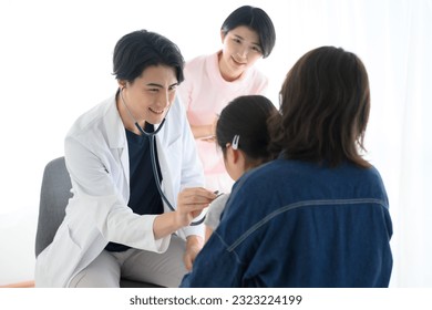 Japanese pediatrician doctor and nurse examining a child, the patient's child and his parents. - Powered by Shutterstock