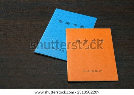 Japanese pension insurance booklet on wooden table. (Written 'pension book')