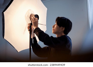 Japanese people adjusting strobe lights in a photo studio - Powered by Shutterstock