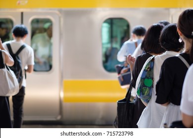 Japanese people queuing for boarding a train in Tokyo. - Shutterstock ID 715723798