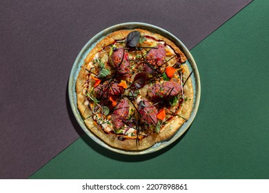 Japanese pizza or flatbread, okonomiyaki, roti, with tuna tartar, fresh avocado, microgreen sprouts, sesame seeds, mango sauce, lettuce, on thin rice dough. Roti lies on a light, round, ceramic plate  - Powered by Shutterstock