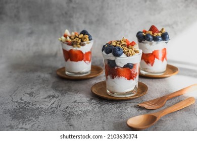 Japanese popular dessert parfait made with fresh fruit, yogurt and granola isolated on cement background