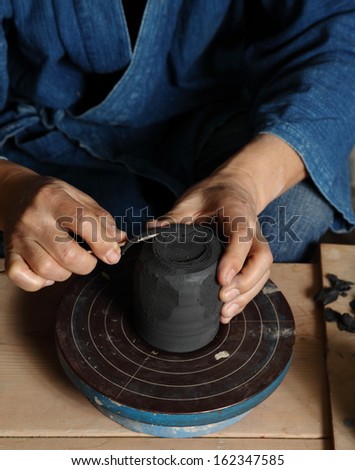 Japanese pottery master working/All in the details/ A Japanese pottery master adding the details to a traditional style ceramic cup