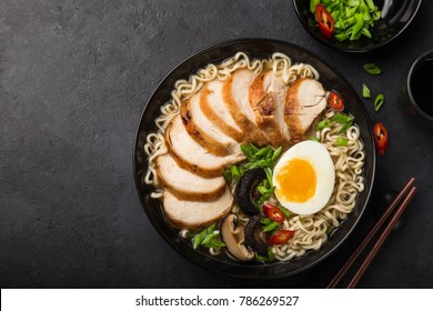 japanese ramen noodle with chicken, shiitake mushroms and egg in black bowl, top view - Powered by Shutterstock