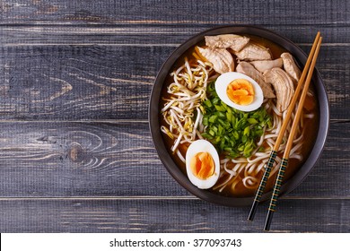 Japanese ramen soup with chicken, egg, chives and sprout on dark wooden background. - Shutterstock ID 377093743