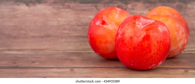 Japanese red plums over wooden background
