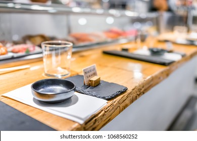 Japanese restaurant sign in traditional style, interior asian sushi wooden bar counter, menu, bowl, glass, napkin setting empty nobody closeup