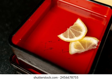 In a Japanese restaurant sliced lime slices are placed in red iron container - Powered by Shutterstock