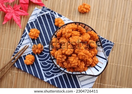 Japanese rice crackers coated with soy sauce - Japanese finger food snack called Otsumami or Age Arare at top view on bamboo placemat 
