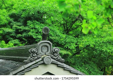 Japanese Roof Gable Looks Decades Back, The Green Background Of The Treetops.