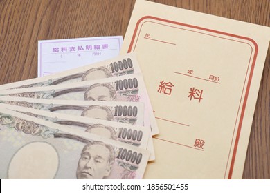 Japanese salary bag and 10,000 yen bill. Translation: Year, Month, Salary, Dear, Pay slip, Year, Month. - Shutterstock ID 1856501455