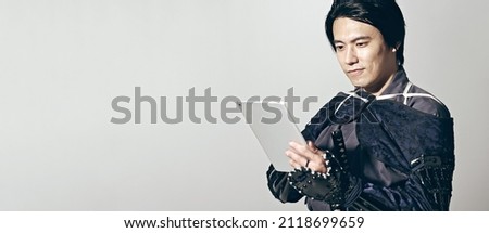 Japanese Samurai using a tablet PC. Japanese traditional warrior.