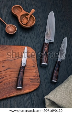  Japanese Santoku knife set. Damascus kitchen steel Knives on Wooden kitchen cutting Board. Kitchen Utensils background with Santoku Japanese knife.