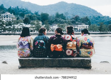 Japanese School Girls Sitting Together In Colourful Kimono Traditional Costume, Miyajima, Japan