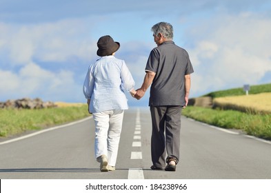 Japanese Senior Couple Walking On The Road, Holding Hand.