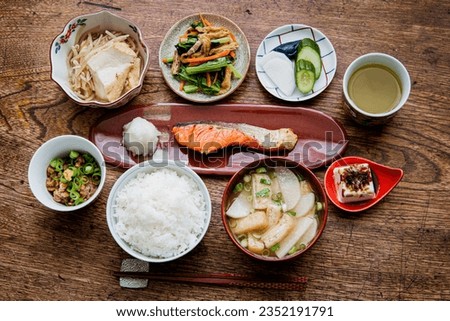 Japanese set meal.Grilled salmon with grated white radish.Rice.White radish ,'Aburaage'(thin fried tofu) and green onion of miso soup.Natto.'Hiyayakko'(cold tofu).Simmered 'Atsuage'(fried tofu) etc.. ストックフォト © 
