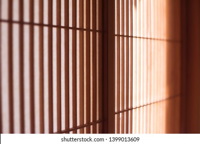 Japanese shoji screen with very fine lattice work, in light and shadow. Extremely shallow depth of field.
