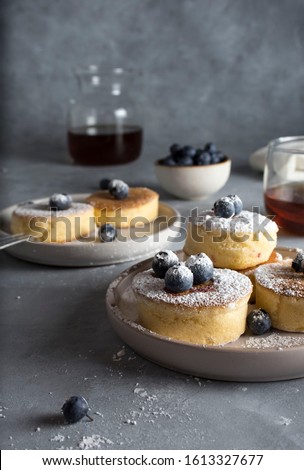 Japanese soft pancakes with raspberries and blueberries sprinkled with powdered sugar