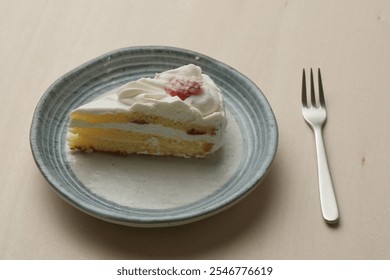 Japanese strawberry shortcake and fork on each stylish large and small plate on a wooden table. - Powered by Shutterstock