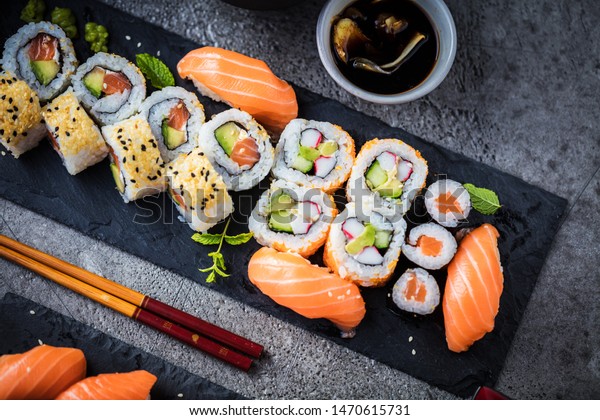 japanese sushi food. Maki ands\
rolls with tuna, salmon, shrimp, crab and avocado. Top view of\
assorted sushi. Rainbow sushi roll, uramaki, hosomaki and nigiri.\

