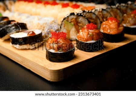Japanese sushi food. Maki rolls with salmon and tobiko calve. Set of rolls on blurred background.