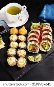 Japanese Sushi Set With Panko Fried Rolls And Vegan Rolls With Shiitake Mushroom And Vegetables And Green Tea On Black Board