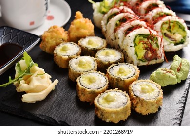 Japanese Sushi Set With Panko Fried Rolls And Vegan Rolls With Shiitake Mushroom And Vegetables And Green Tea On Black Board