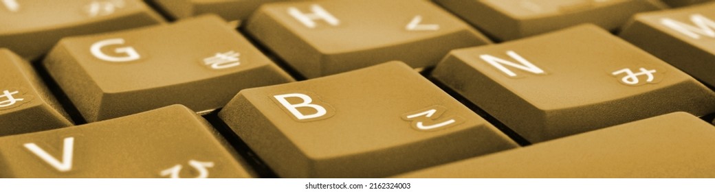 Japanese Typing. Dark Yellow Laptop Keyboard Closeup. Symbols On Buttons Of Hiragana. Light Brown Tinted Computer Header Or Banner. Electronic Commerce In Japan. IT Technology And Data Storage