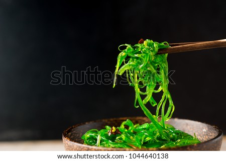 Japanese Wakame Seaweed Salad with Chopsticks, close up. Healthy vegetarian seafood