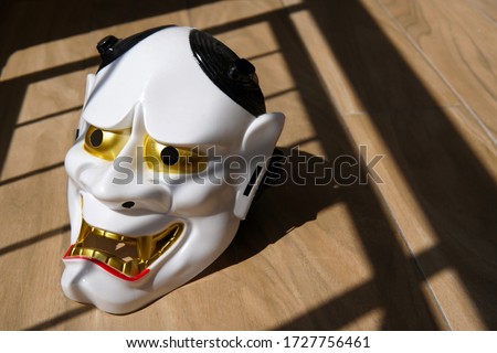 Japanese white ghost mask on wood floor                            
