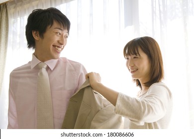 Japanese Wife Putting A Suit Jacket On Husband