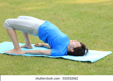 Japanese woman doing yoga Bridge Pose