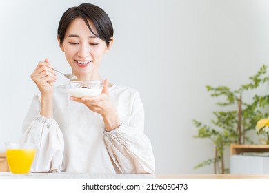 Japanese woman eating breakfast at home - Powered by Shutterstock